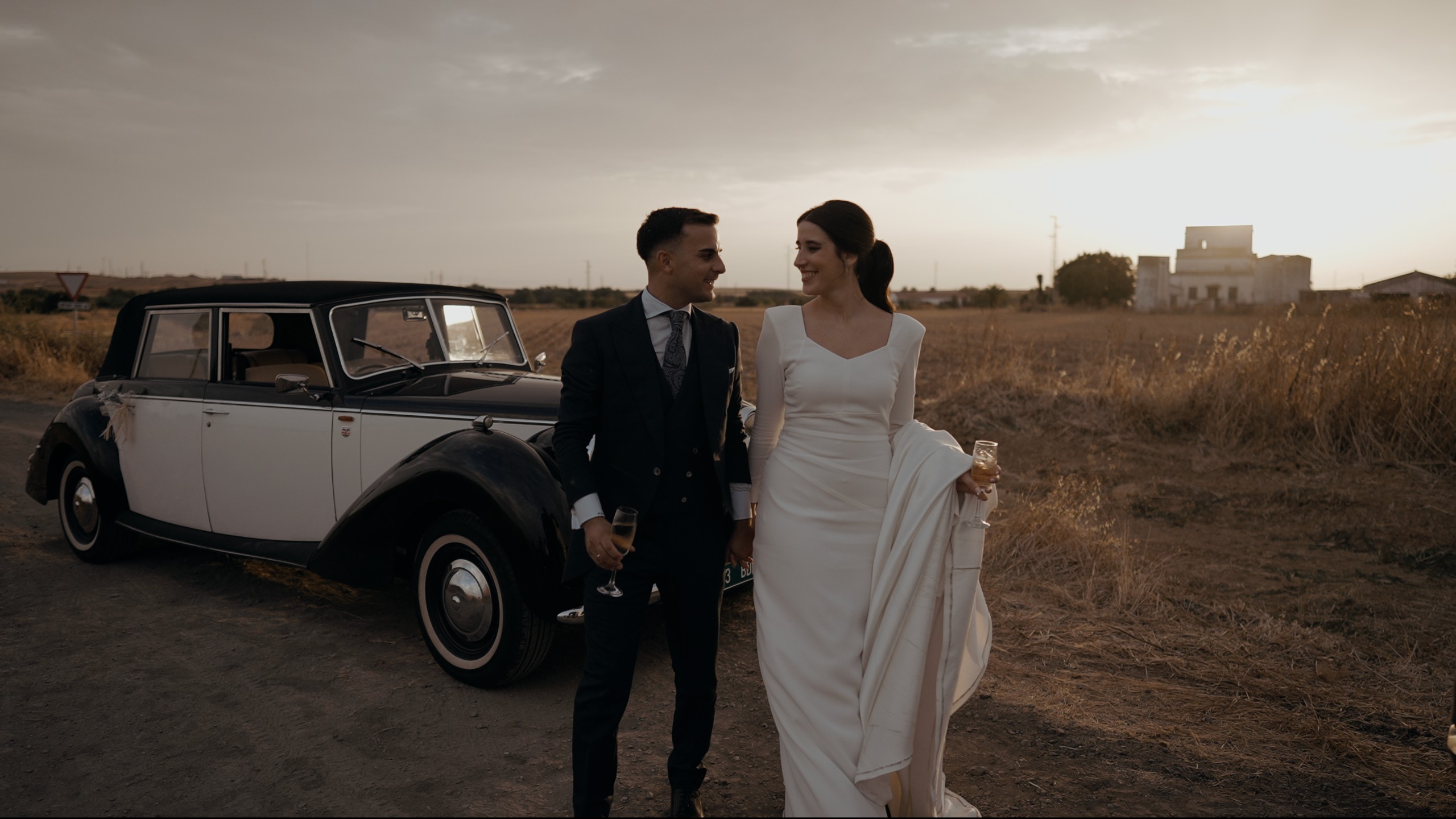 Ana y David junto a un coche clásico de 2R Clásicos, en el campo de Huelva