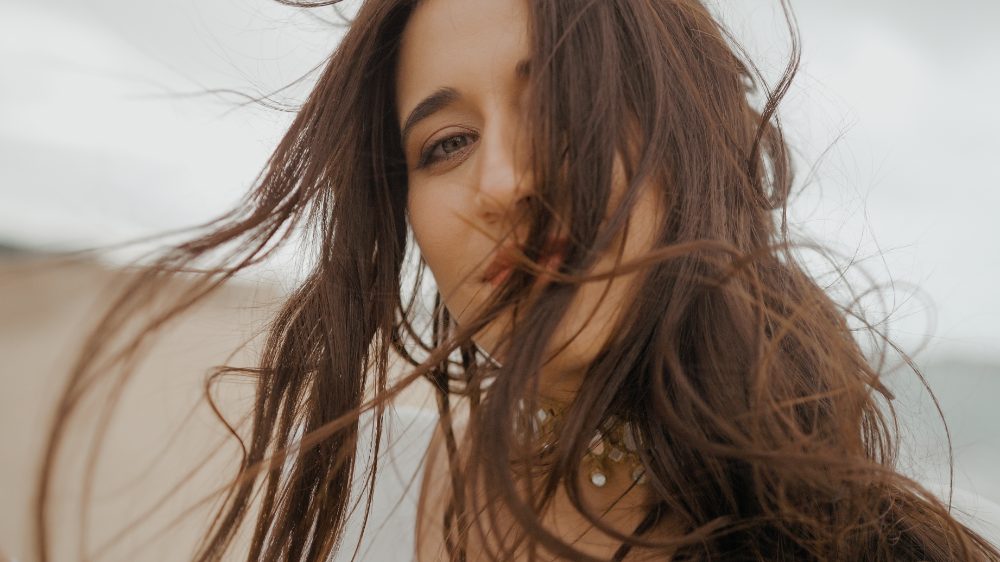 Ana con el pelo al viento en su postboda en Cádiz, frente al mar