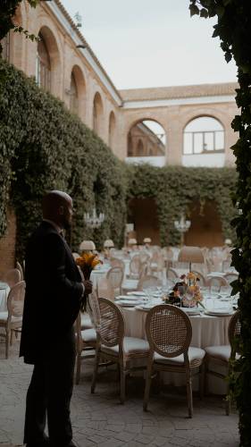 Juan con el ramo de calas naranjas, esperando en el patio del Convento de la Luz antes del banquete