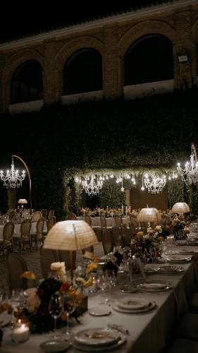 El patio del Convento de la Luz de noche, con el banquete montado bajo lámparas de araña y los arcos de ladrillo