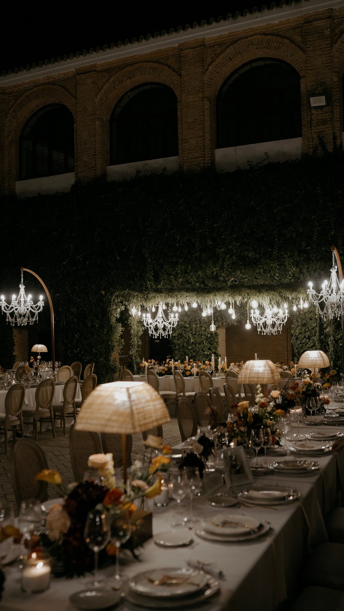 The courtyard of Convento de la Luz at night, with dinner laid out under chandeliers