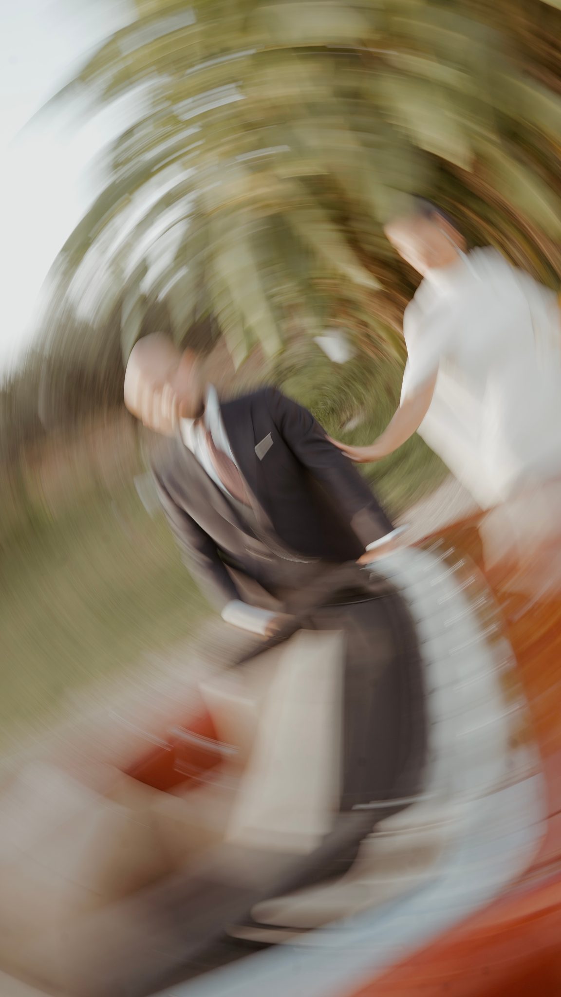 Rocío y Juan en movimiento, de la mano junto al coche de la boda