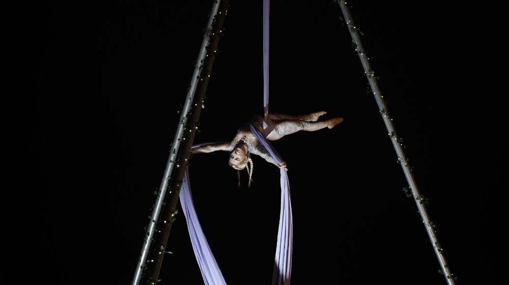 Un número de telas aéreas de noche, con lucecitas en la estructura