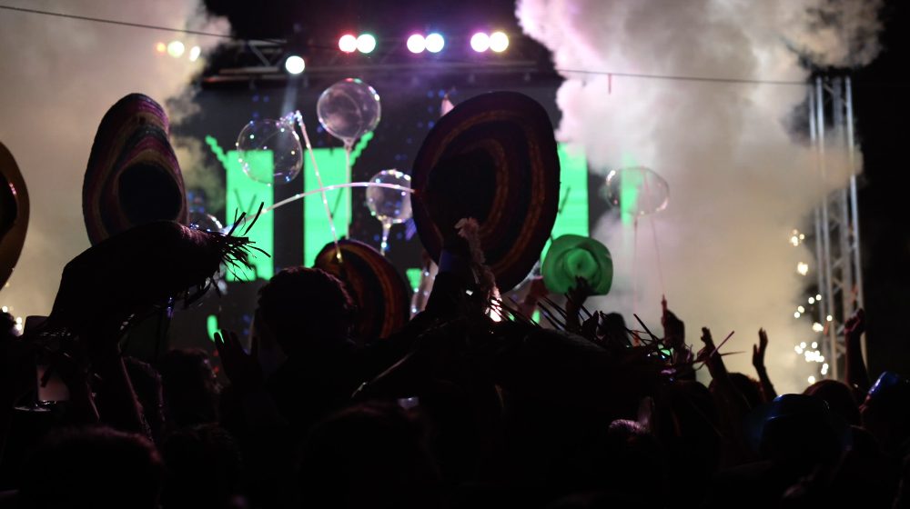 El público de la hora loca, con sombreros y globos, entre humo y luces verdes