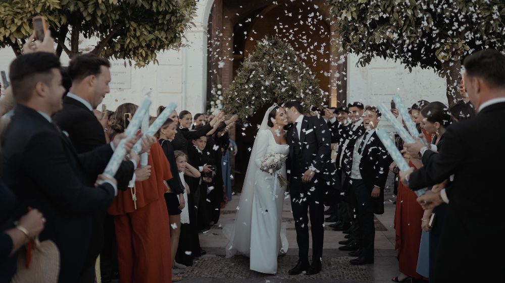 Patri and Juanma leave the ceremony among their guests, under a shower of rice and confetti