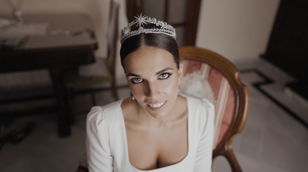 Patri, wearing the tiara, smiles at the camera seated in an armchair before the ceremony