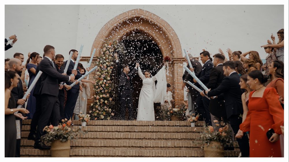 The exit from the ceremony among the guests, confetti in the air · Gearmedia