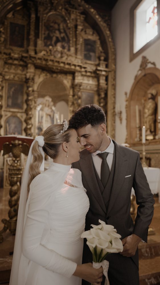 Alicia y Edu, frente con frente, ante el retablo barroco de la Ermita de Nuestra Señora de Belén, en Pilas
