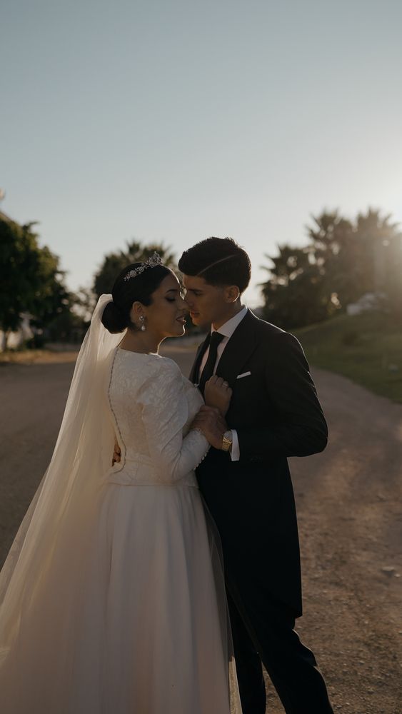 An embrace with the veil in the wind on a path, low sunset light · Gearmedia