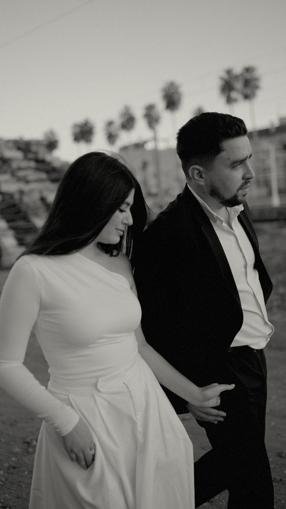 Black and white: close-up of the couple in profile with palm trees behind · Gearmedia
