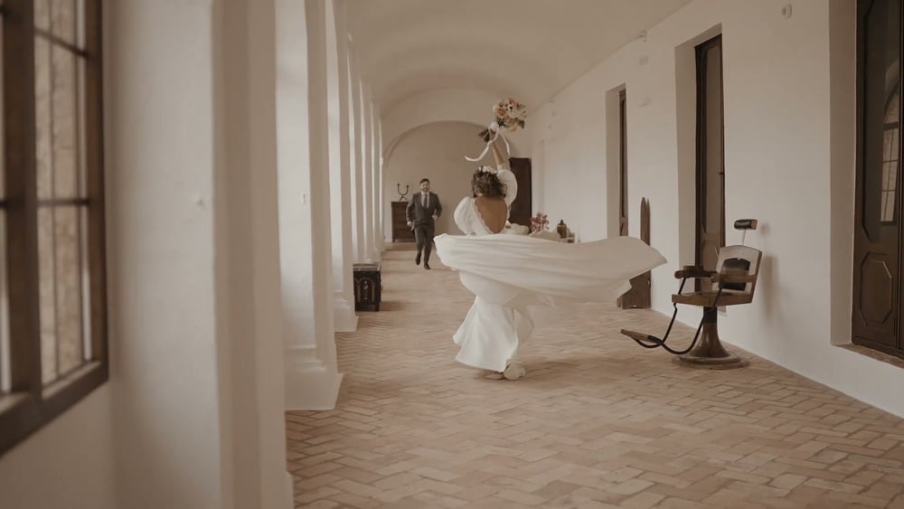 May spins in a white arcaded corridor of the convent, her skirt flying, Juan walking behind her