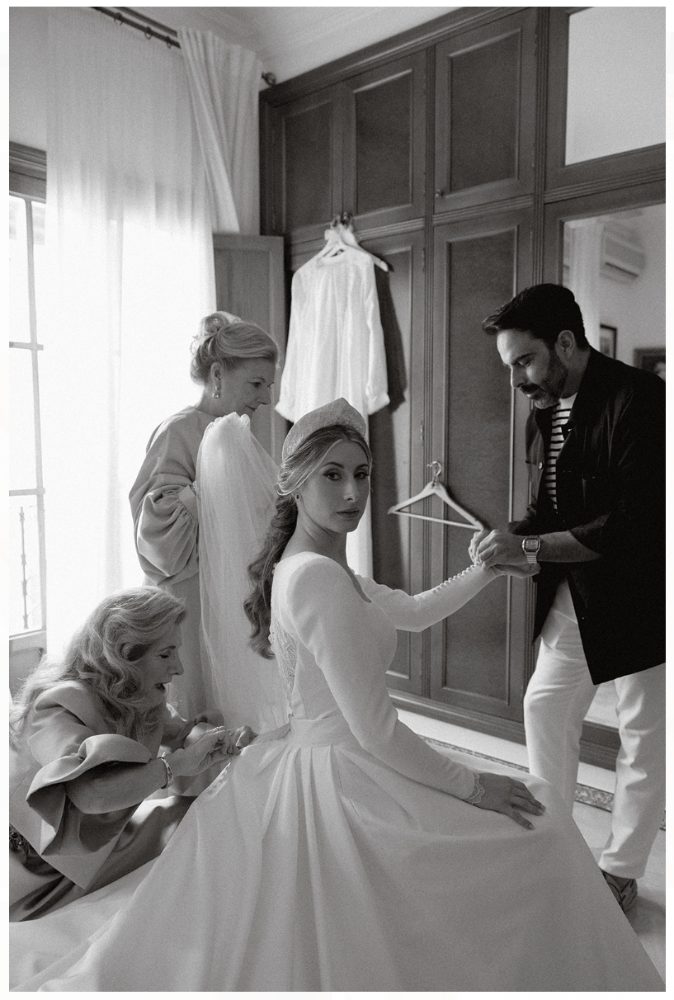 Designer Iván Campaña doing up the sleeve of Ana’s wedding dress on her wedding day