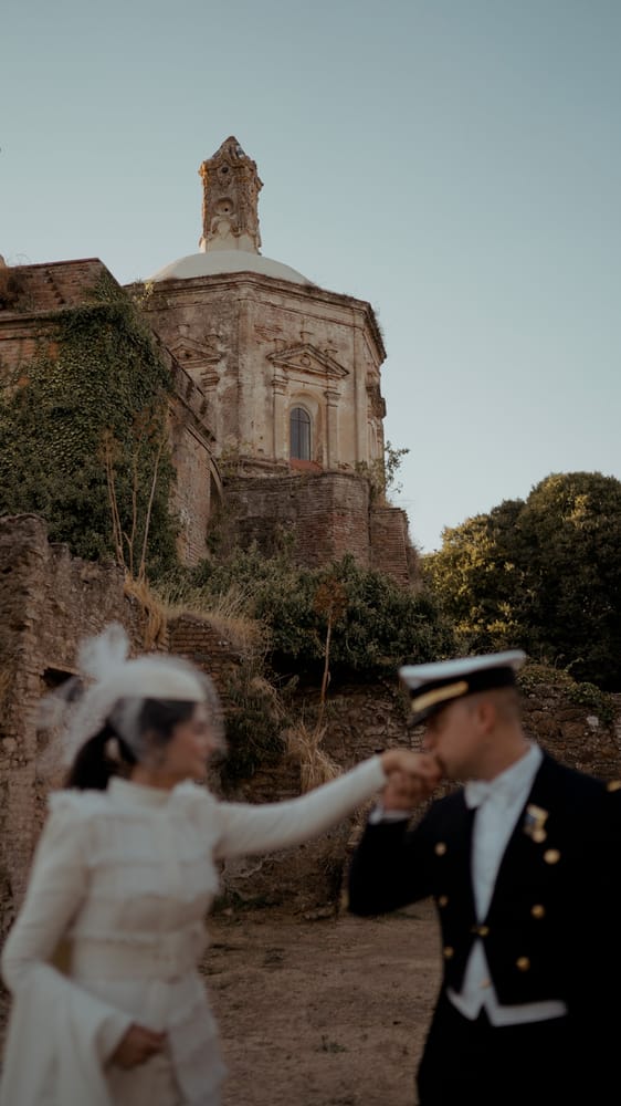 El novio besa la mano de la novia ante una iglesia en ruinas, en La Cartuja de Cazalla, Sevilla