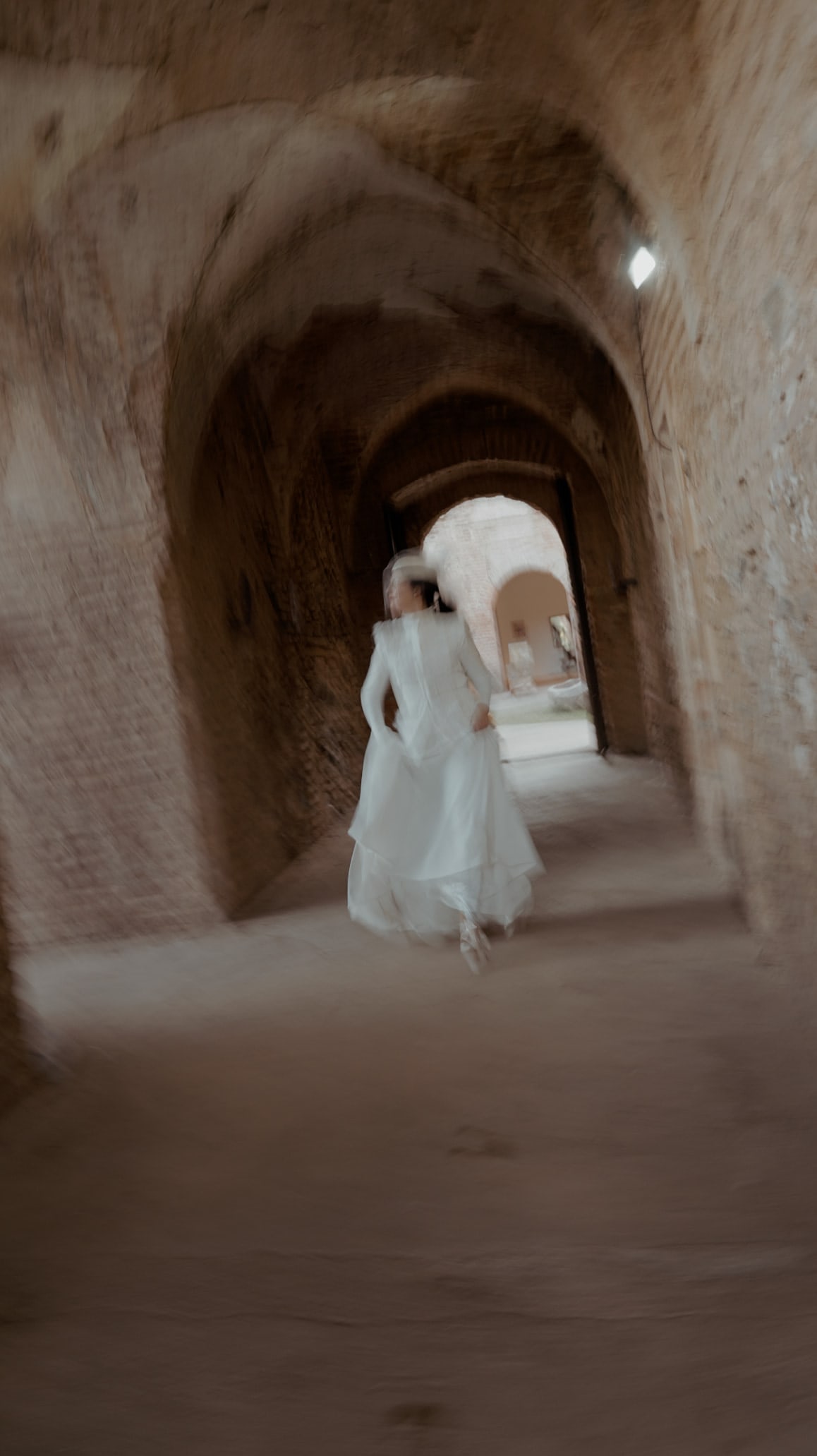Novia corriendo por un pasadizo abovedado, en La Cartuja de Cazalla, Sevilla