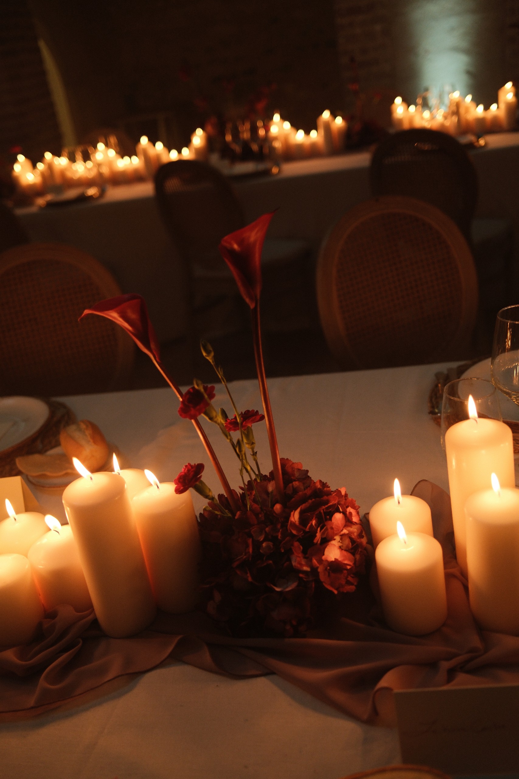 Centro de mesa con velas, calas rojas y flores granates, en el Convento de la Luz, Huelva