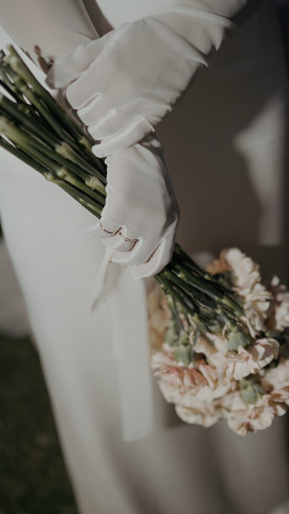 Novia con guantes de tul y un ramo de claveles · Gearmedia y Cupido debe morir