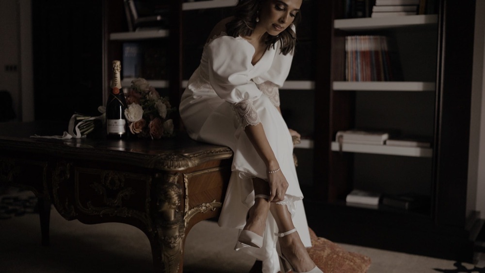 May poniéndose los zapatos sentada en un escritorio antiguo del Hotel Alfonso XIII de Sevilla · Gearmedia