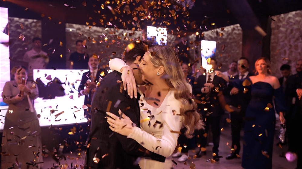 Novios besándose en la pista de baile entre confeti dorado, en una boda en Huelva · Gearmedia
