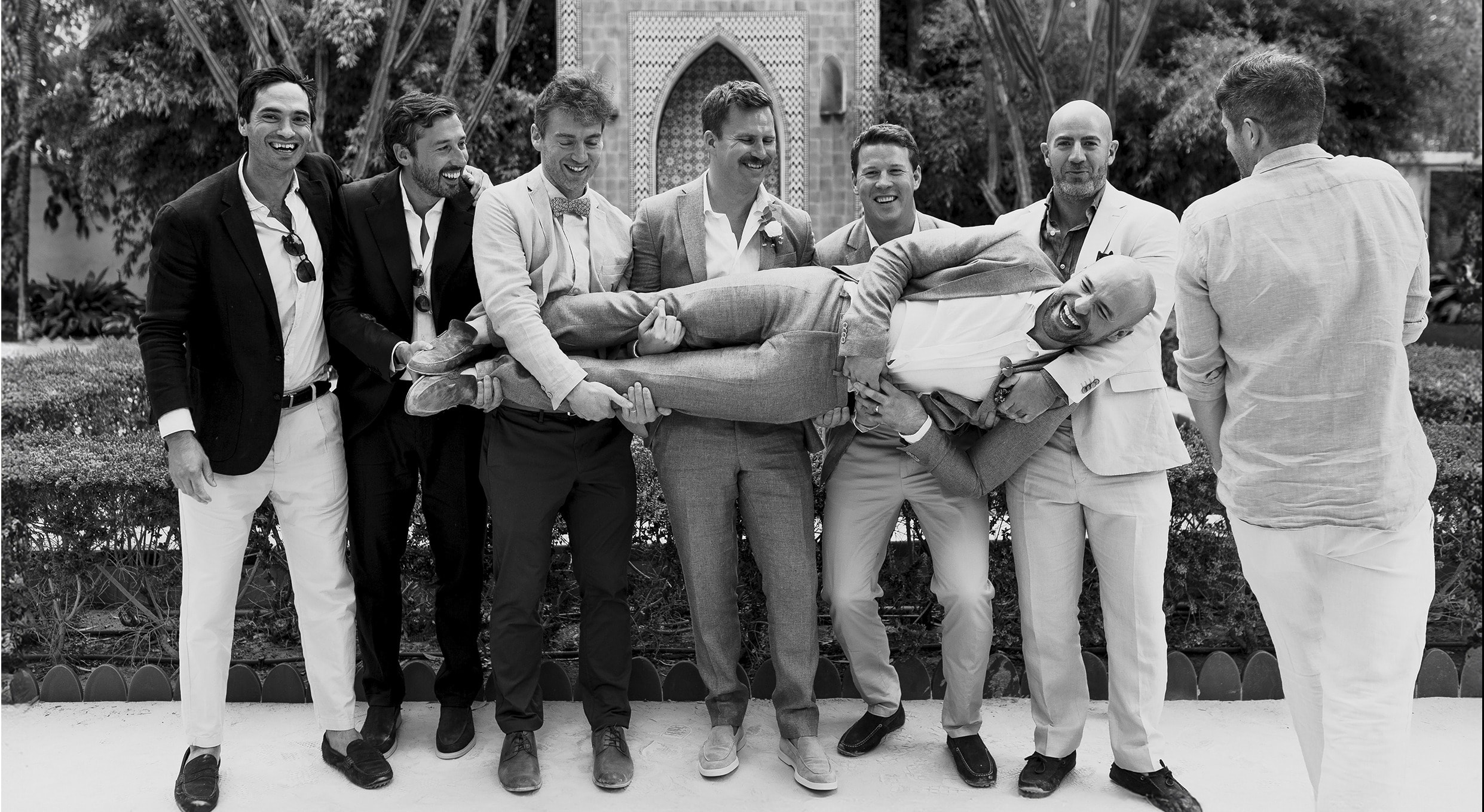 Amigos del novio sosteniéndolo en brazos, en blanco y negro · Gonzalo Lagares