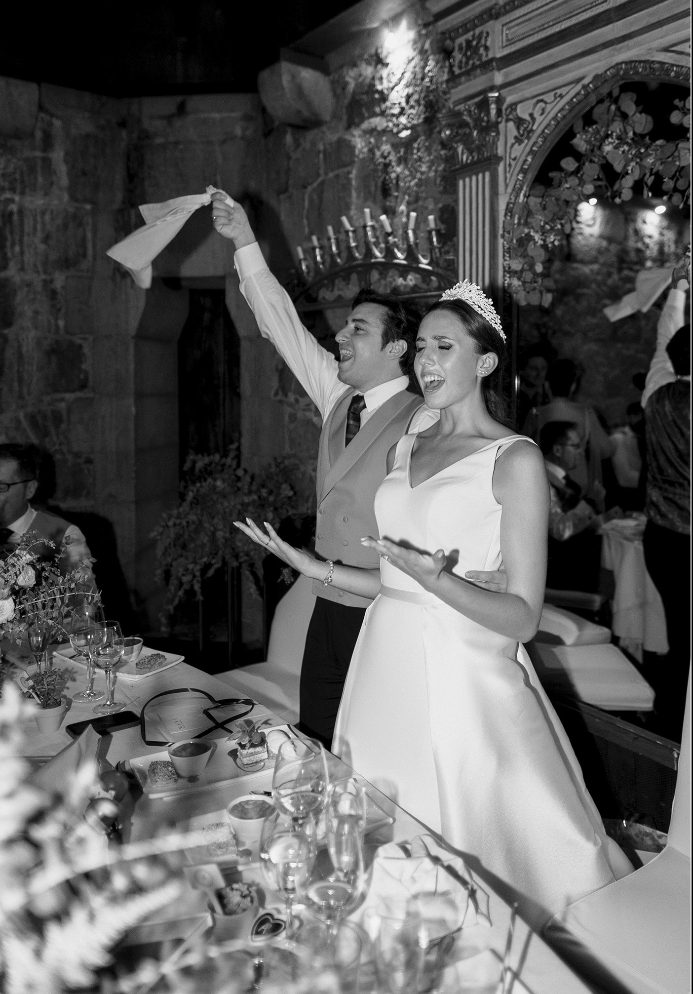 Novios cantando y bailando sobre la mesa del banquete, en blanco y negro · Gonzalo Lagares