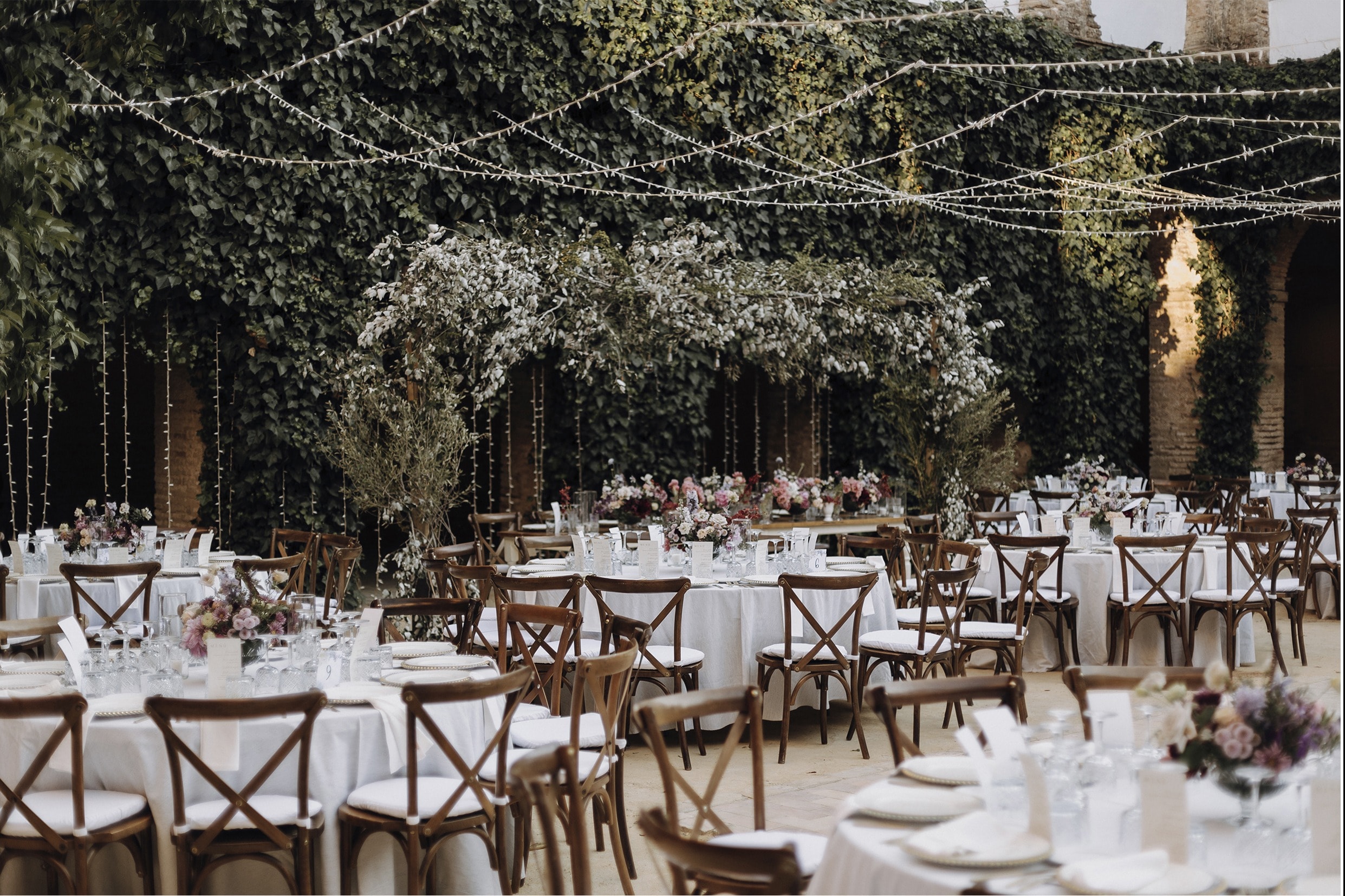 Banquete al aire libre entre hiedra y guirnaldas de luces · Gonzalo Lagares