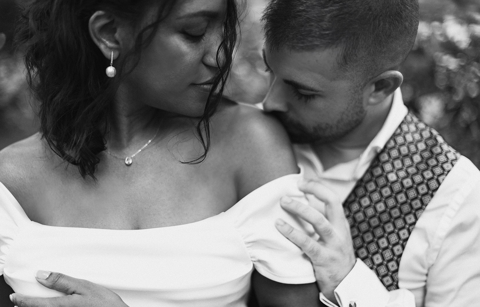 Pareja abrazada, él besa el hombro de ella, en blanco y negro · Gonzalo Lagares