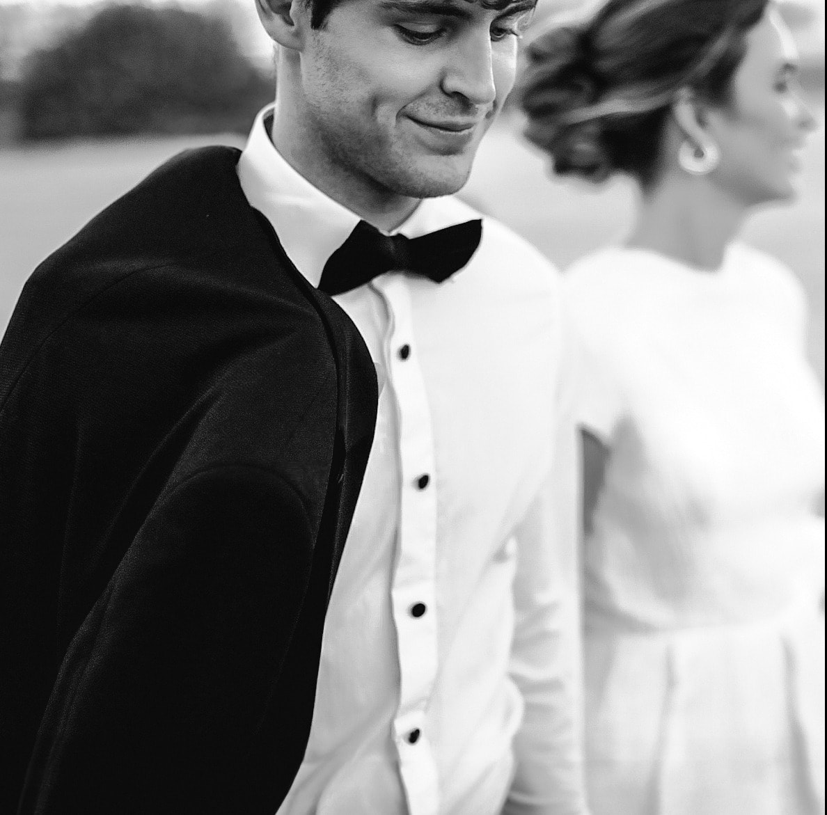 Novio con capa y pajarita junto a la novia, en blanco y negro · Gonzalo Lagares