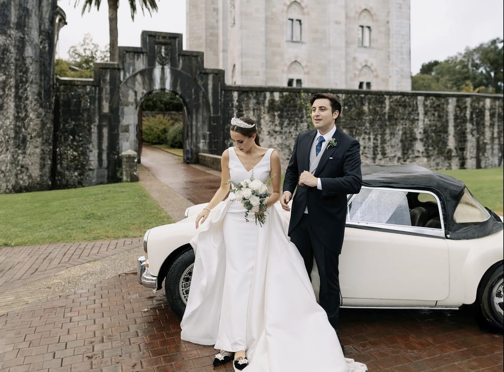 Novios junto a un coche clásico blanco frente a un castillo · Gonzalo Lagares
