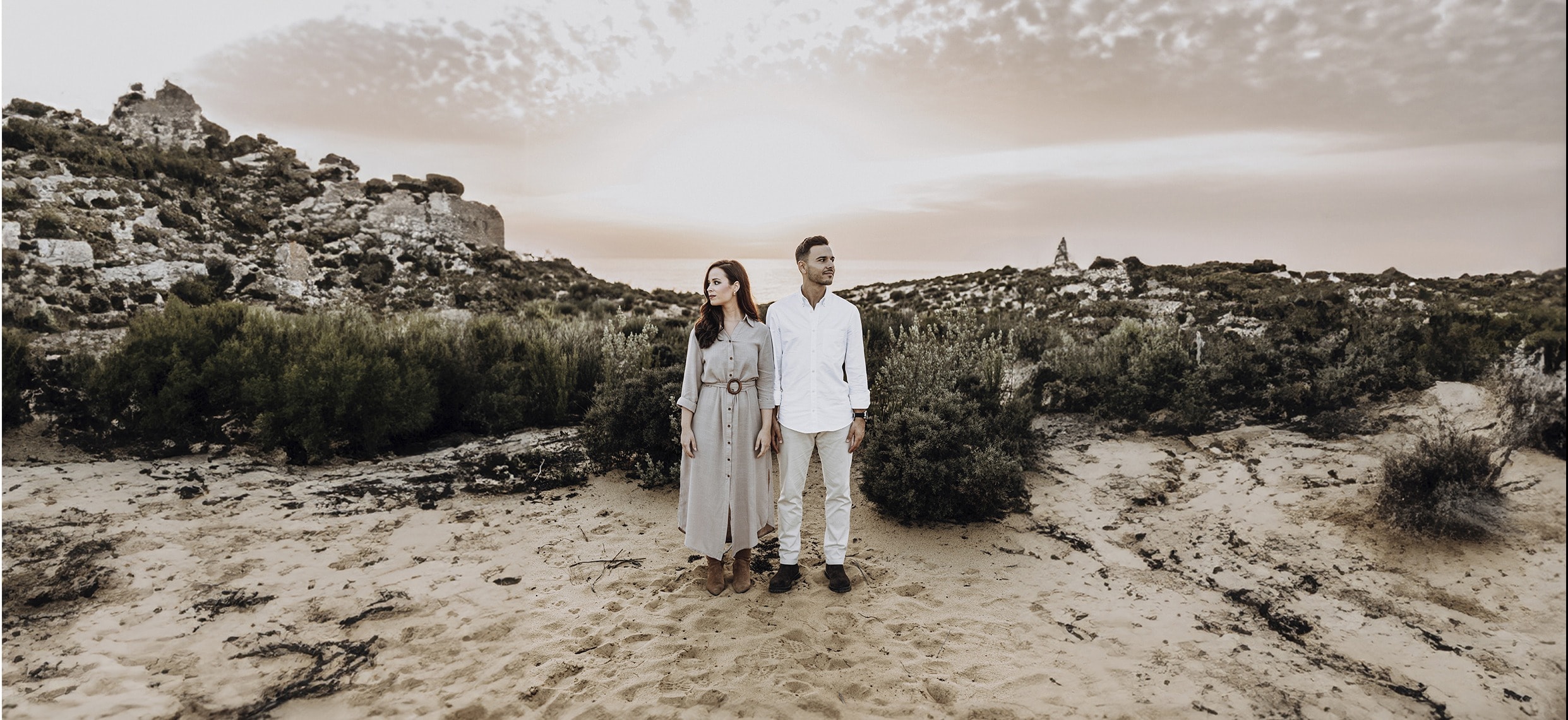 Pareja en un paisaje de dunas y arbustos al atardecer · Gonzalo Lagares