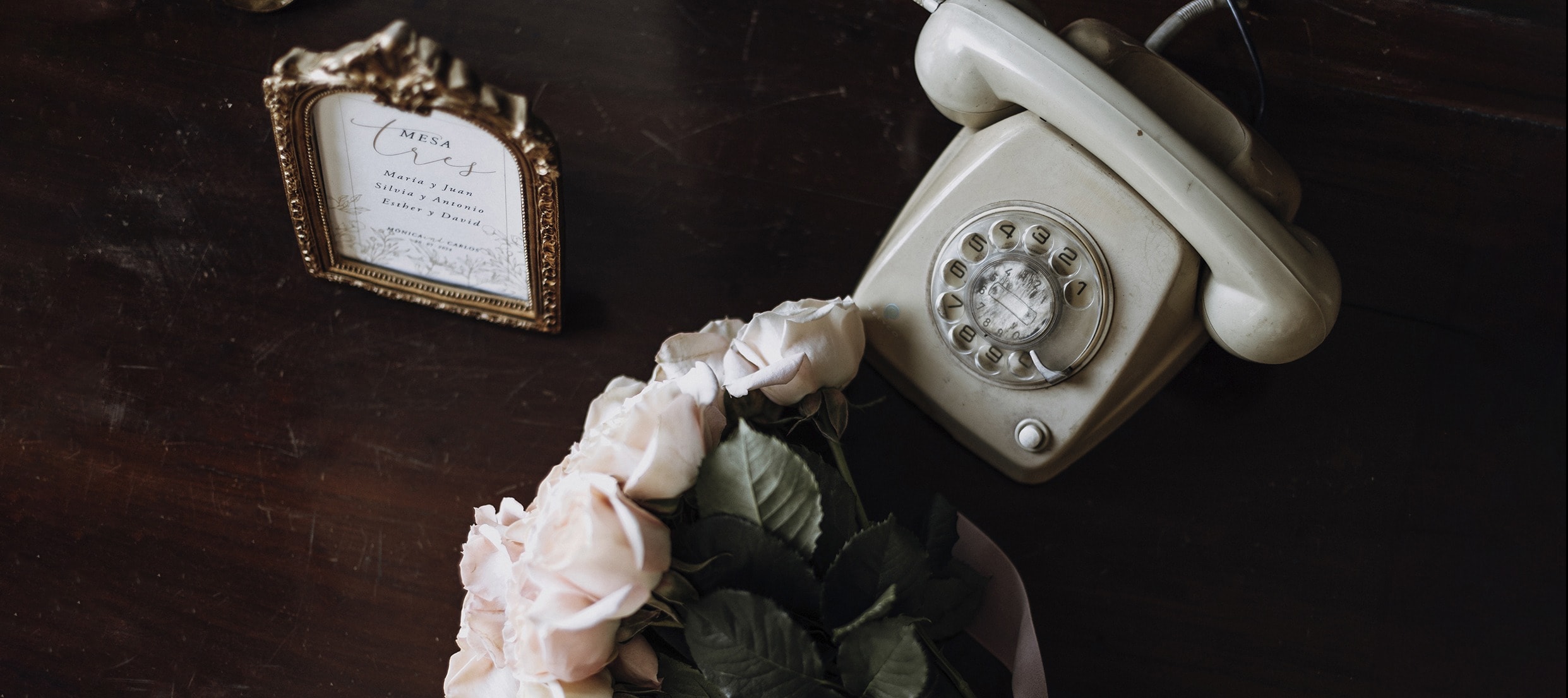 Detalle de boda: teléfono antiguo, rosas y un marco con el nombre de los novios · Gonzalo Lagares